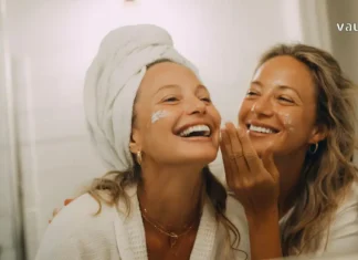 თავის მოვლა, როგორც ინვესტიცია საკუთარ თავში: თანამედროვე გზამკვლევი Two cheerful women applying face cream and enjoying a skincare routine together in a bathroom.