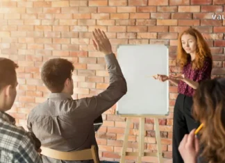 რატომ არის ტრენინგები საუკეთესო ინვესტიცია თქვენს მომავალში? Professionals attending a business training workshop with a world map and airplane icon representing educational travel