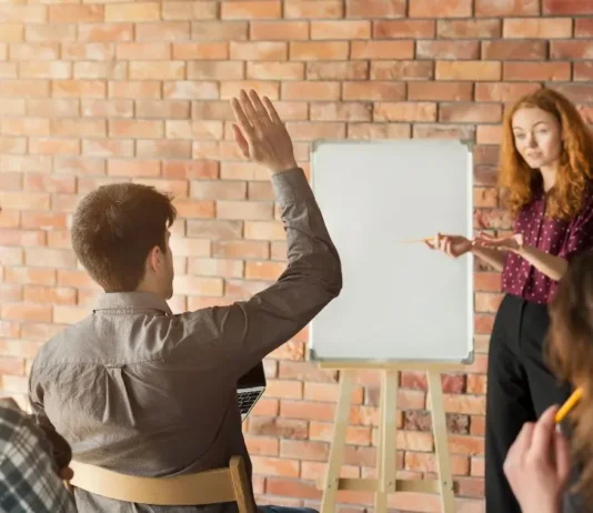 რატომ არის ტრენინგები საუკეთესო ინვესტიცია თქვენს მომავალში? Professionals attending a business training workshop with a world map and airplane icon representing educational travel