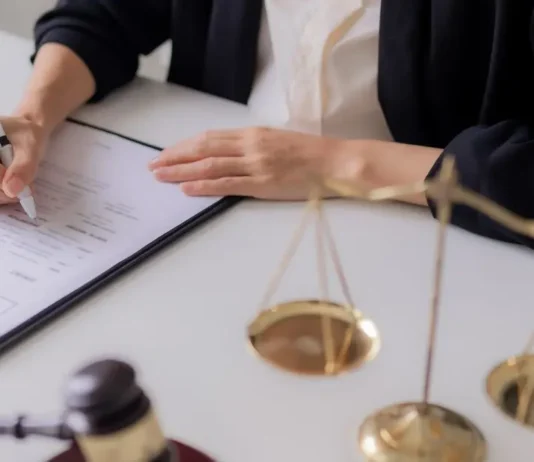 სამართლებრივი უსაფრთხოება ბიზნესში: სტრატეგიული გზამკვლევი მეწარმეებისთვის A professional setting showing legal documents, a pen, and the scales of justice representing commercial law and business contracts.