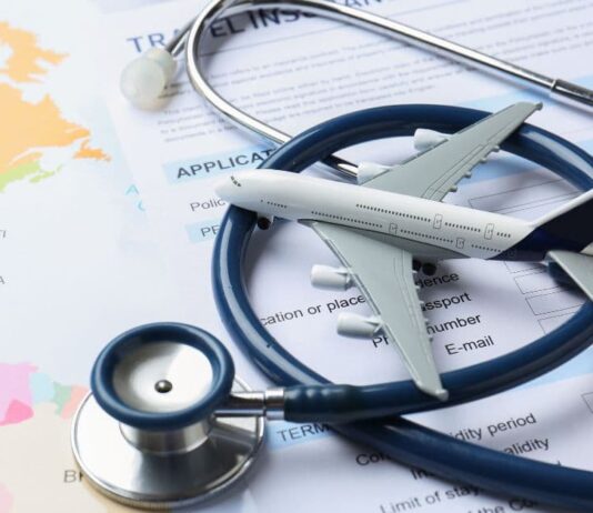 მედიცინა საზღვრების გარეშე: როგორ დავგეგმოთ სამედიცინო ტურიზმი ეფექტურად Stethoscope on a world map with a passport and airplane icons representing medical tourism.