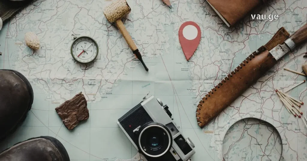 Vintage travel accessories on a map including a camera, compass, and wooden pipe.