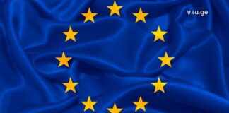 ევროპული თავისუფლების გზა: 2017 წლამდელი ბარიერები და 2026 წლის გაურკვევლობა Waving European Union flag with blue fabric and yellow stars, representing Georgia's visa-free travel and European integration.