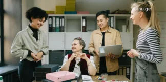 მომავალი მათ ხელშია: რომელი პროფესიები იზიდავს Gen Z-ს? A diverse group of young Gen Z professionals collaborating and smiling in a modern office setting.