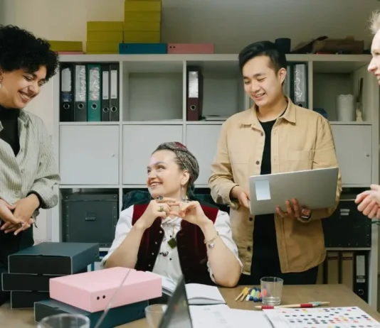 მომავალი მათ ხელშია: რომელი პროფესიები იზიდავს Gen Z-ს? A diverse group of young Gen Z professionals collaborating and smiling in a modern office setting.