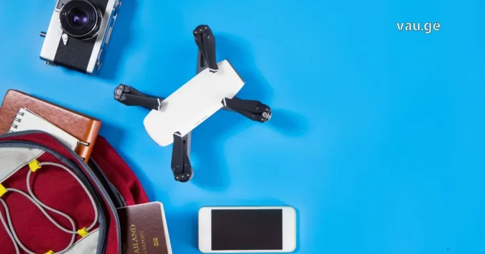 A collection of modern travel gadgets including noise-canceling headphones, a power bank, and a smartphone on a flat surface