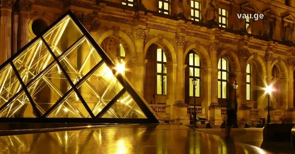 The glowing Louvre Pyramid at night with illuminated palace museum.