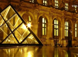 თბილისი-პარიზი: როგორ ვიპოვოთ იაფი ავიაბილეთები და დავგეგმოთ ბიუჯეტური ტური The glowing Louvre Pyramid at night with illuminated palace museum.